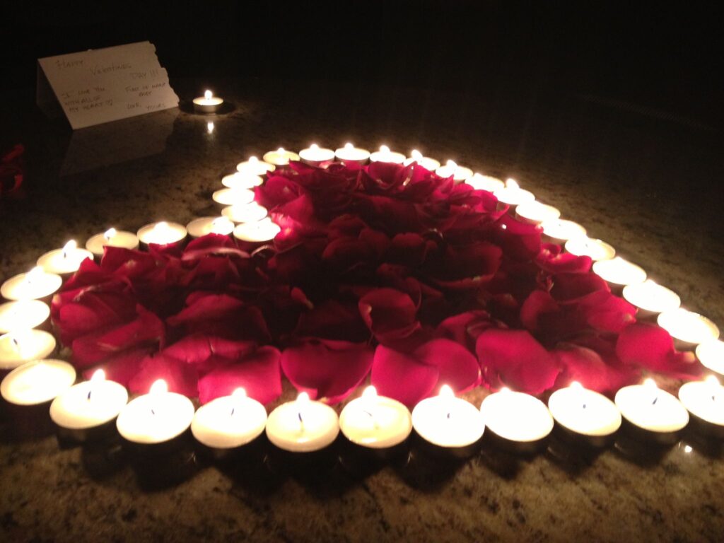 Heart-shaped rose petals and candles in the bedroom